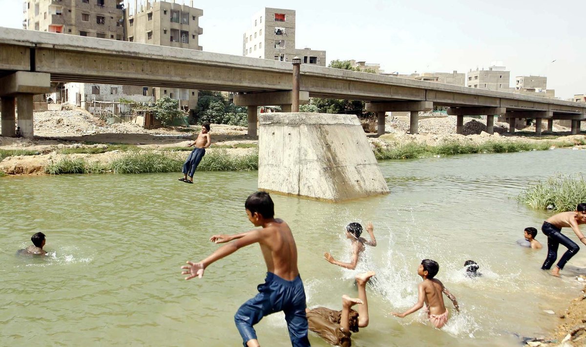 KLIIMAKRIISI NÄHUD: Pakistani suurima linna Karachi asukad kurdavad, et kuumus on elu talumatuks muutmas, eriti, kui puudub ligipääs konditsiooneerile ja puhtale veele. Fotol Karachi lapsed end linna tiigis jahutamas.