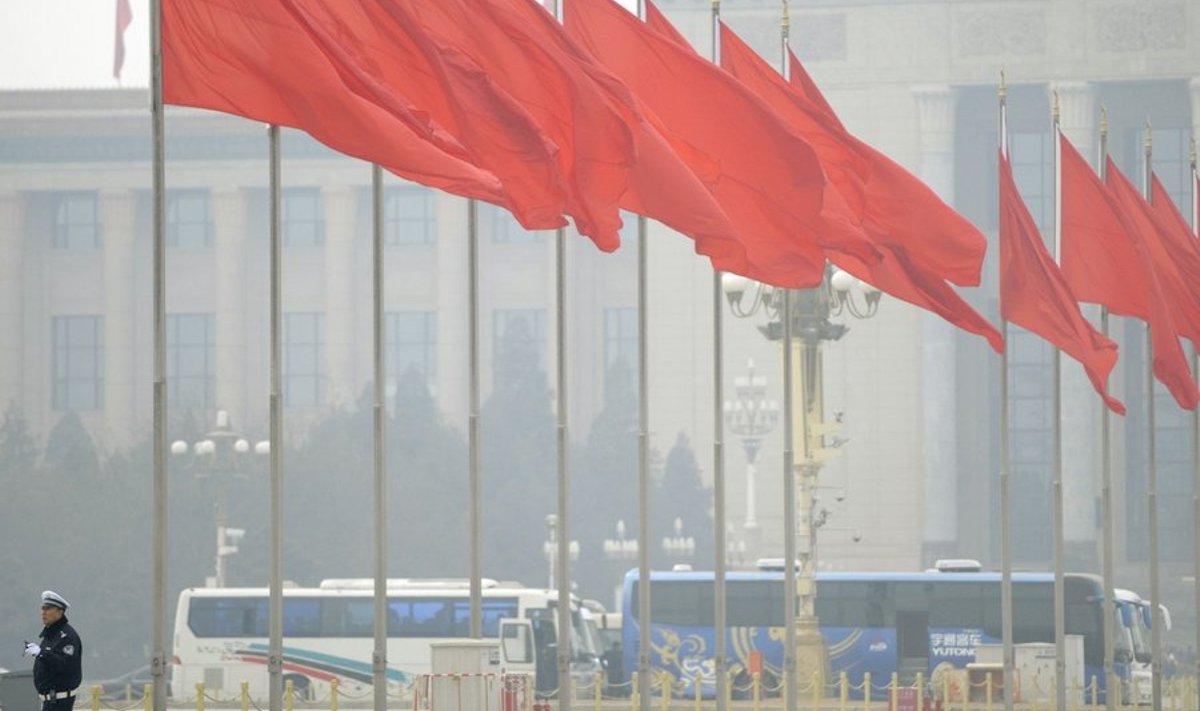 A Chinese policeman walk beneath red flags in front of the Great Hall of the People prior to the opening session of the Chinese People's Political Consultative Conference (CPPCC) in Beijing on March 3, 2010. The congress is often described as a rubber-stamp parliament for the nation's Communist Party rulers, and laws are always passed with overwhelming majorities. But some observers say dissenting voices do get heard in the law preparation stage -- behind closed doors. AFP PHOTO/ LIU Jin