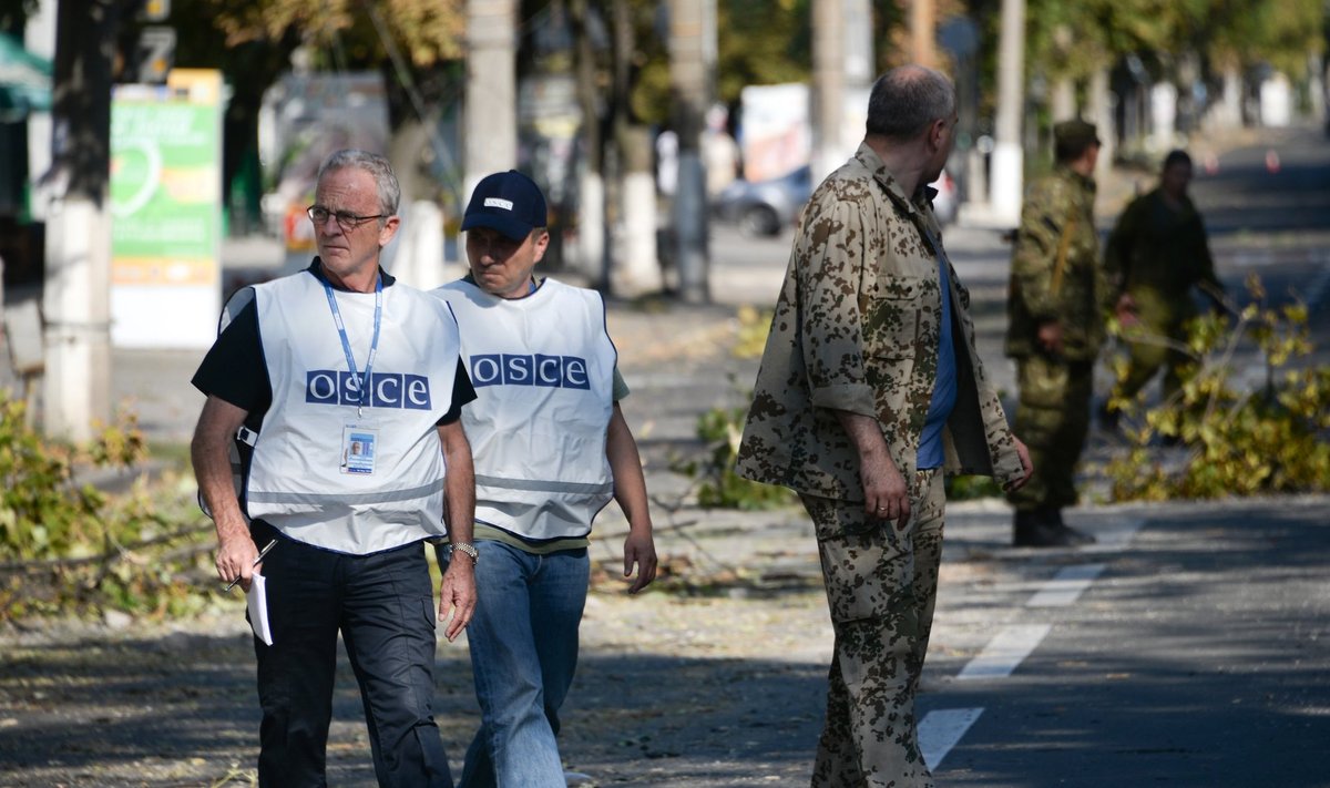 Members of the OSCE examine the scene of a shelling in the town of Donetsk, eastern Ukraine