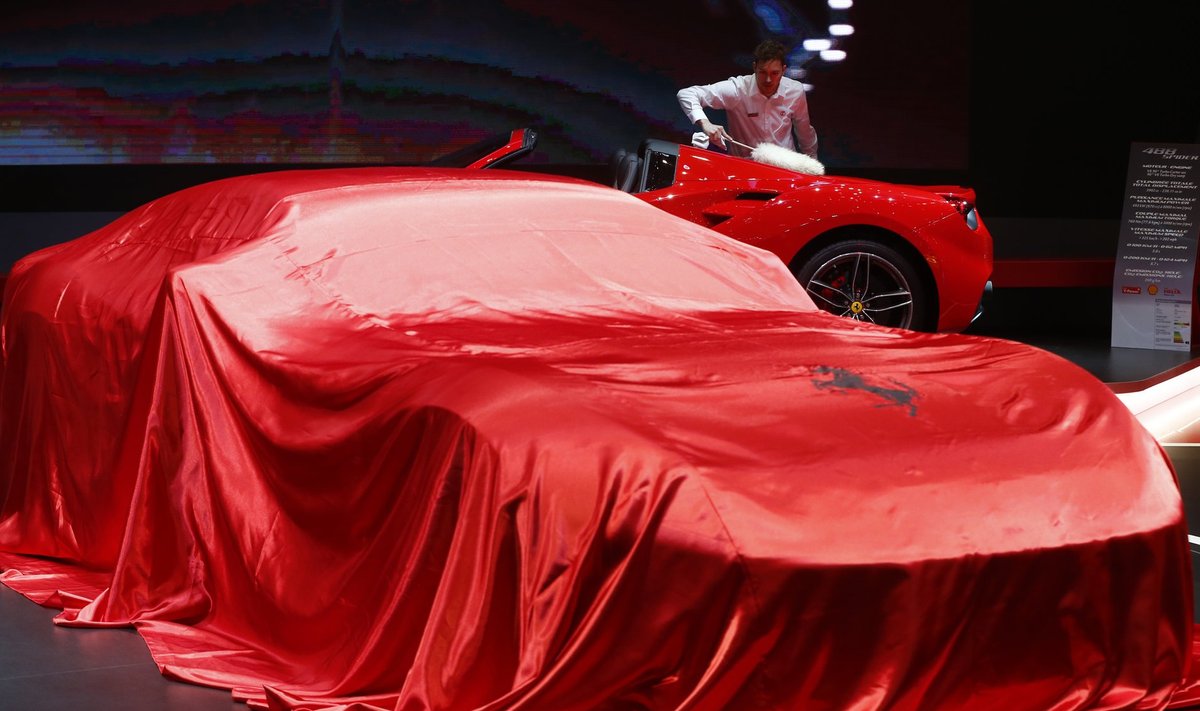 Ferrari puhkab punase teki all. Tagaplaanil puhastatakse sõsarautot viimaseid kübemeid.