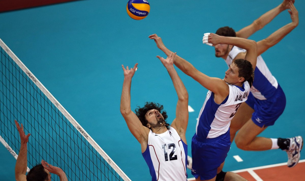 Russia's Alexander Butko sets up a spike for Nikolay Apalikov and Maxim Mikhaylov against David Lee of the U.S. during their men's Group B volleyball match at Earls Court during the London 2012 Olympic Games
