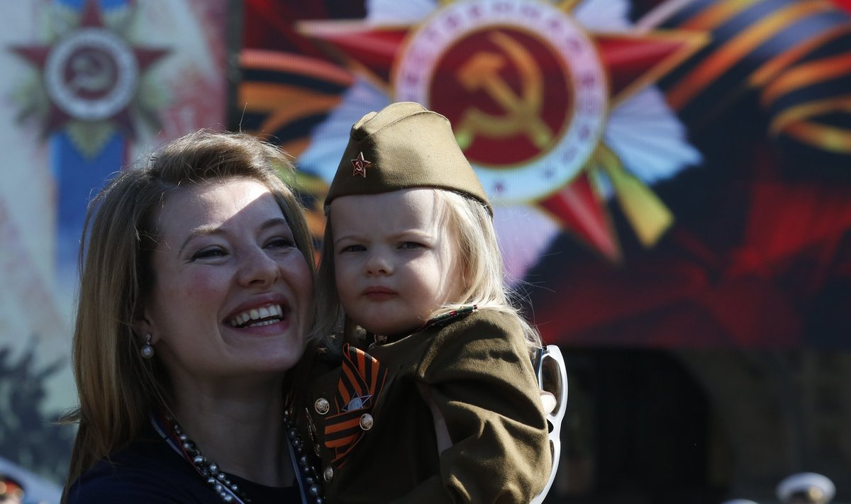 Woman and girl dressed in historical Red Army uniform wait before watching Victory Day parade to mark end of World War Two at Red Square in Moscow