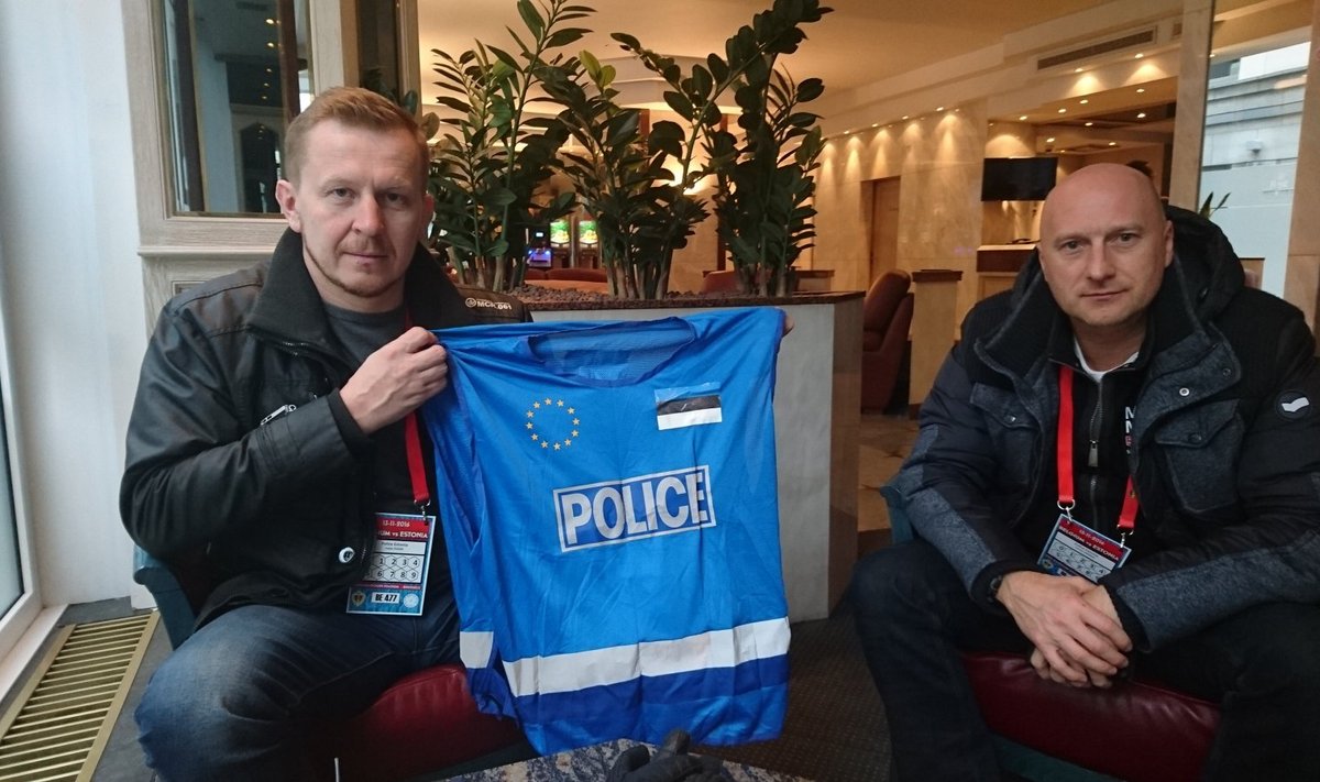 Valdo Põder näitab vesti, mille järgi Eesti politseinikud Brüsselis ära tunneb, kõrval endine lõvipoiss Tarmo Viikmaa.