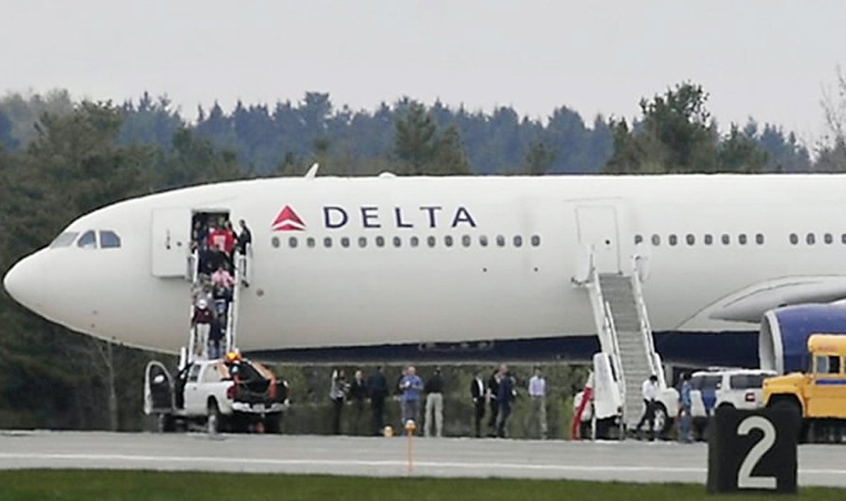 ** RETRANSMISSION FOR ALTERNATE CROP **People walk out of this Delta Air Lines Flight from Paris to Atlanta which was diverted to Bangor International Airport in Bangor, Maine Tuesday April 27, 2010. U. S. officials say an American citizen on the flight claimed to have a fake passport and explosives in his luggage. According to Delta spokeswoman Susan Elliott there were 235 passengers and eight crew aboard the Airbus 330. Aftet the plane landed safely at 3:37 p.m.,  the passengers deplaned onto the tarmac at BIA and boarded buses to BIA's international arrivals building.  (AP Photo/Bangor Daily News, John Clarke Russ) / SCANPIX Code: 436