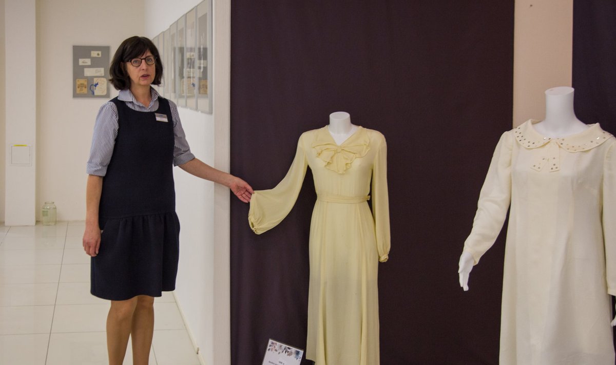 Saaremaa kaubamaja infotöötaja Maris Pavelson tutvustamas näituse kõige vanemat kleiti, milles on abiellunud nii ema kui ka tütar. 