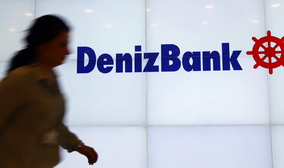 A Denizbank employee walks past by the company's logo at Turkey's Denizbank headquarters in Istanbul