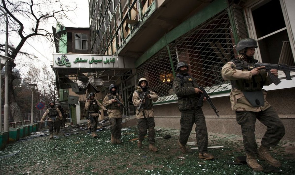 Afghan military personnel rush past Kabul City Centre shopping mall during a fire fight with the Taliban in Kabul February 26, 2010. Foreigners were among at least nine people killed and 18 wounded in Taliban attacks in Kabul on Friday, officials said, the latest audacious assault in the Afghan capital despite a renewed push against the insurgents.  REUTERS/Ahmad Masood (AFGHANISTAN - Tags: CIVIL UNREST)