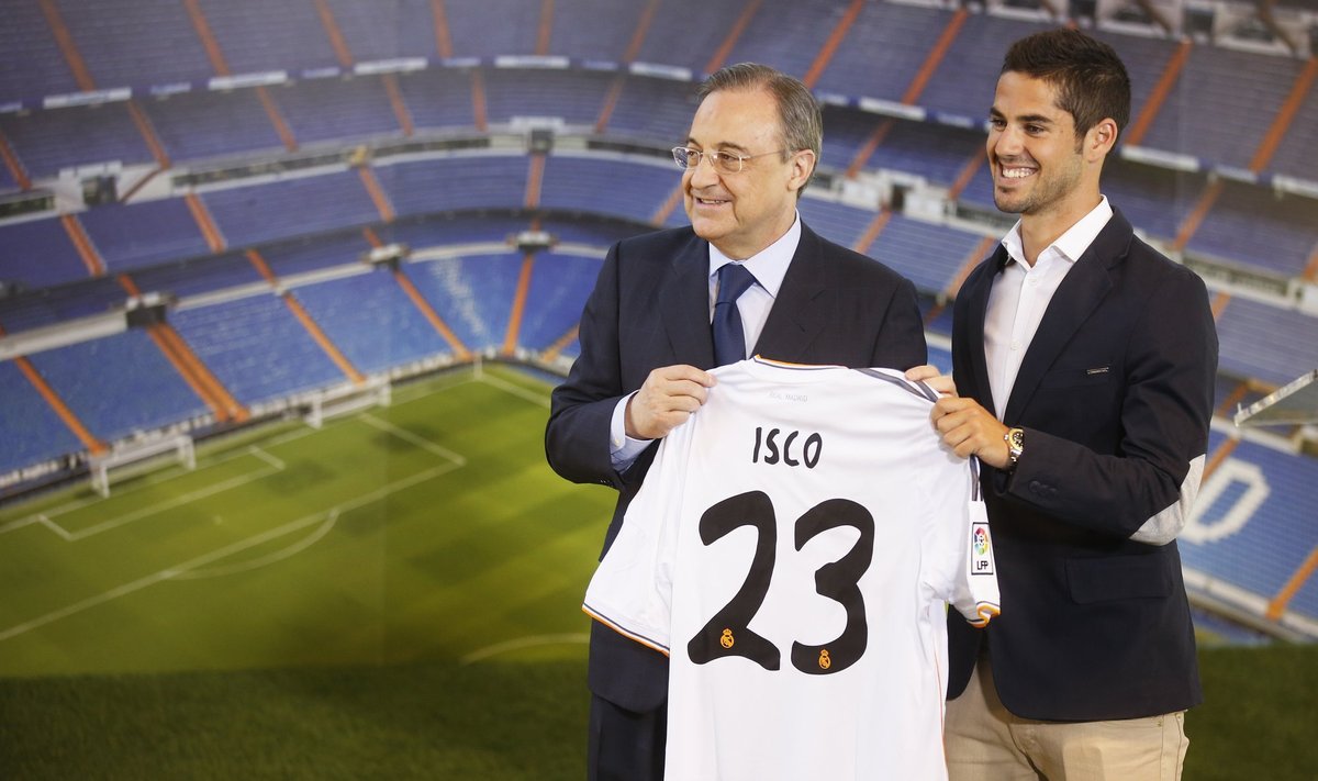 Real Madrid's new signing Isco holds a Real Madrid jersey as he poses with the club's President Perez during his presentation at Santiago Bernabeu stadium in Madrid