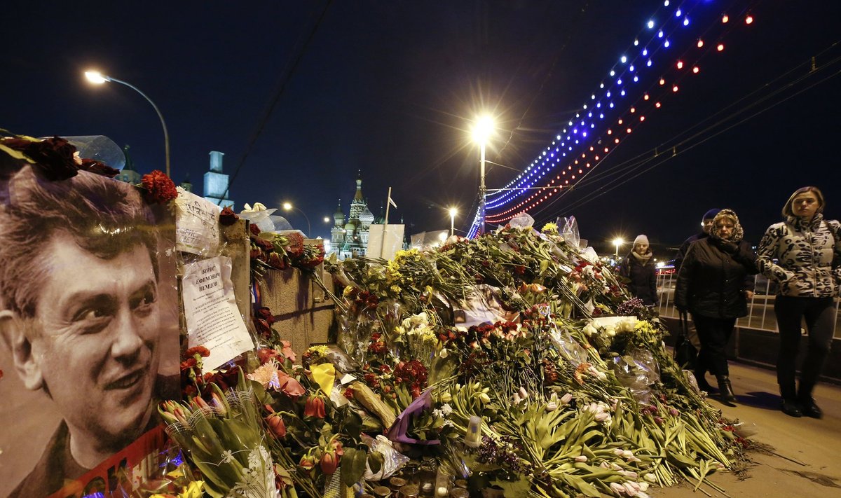 People walk past flowers at site where Russian politician Nemtsov was killed in central Moscow