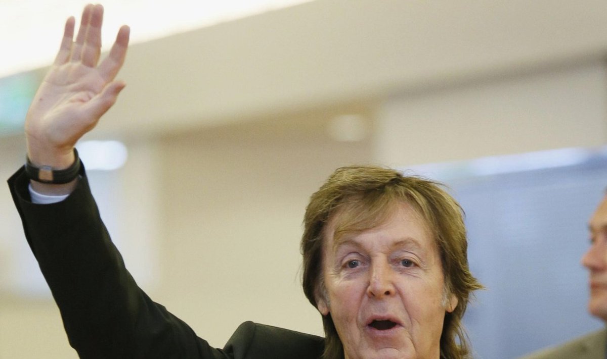 Singer McCartney waves to fans upon his arrival at Tokyo's Haneda international airport