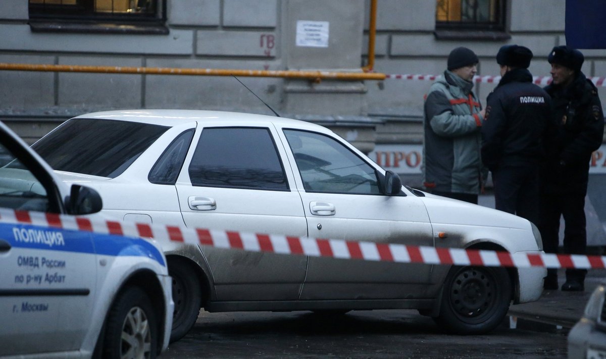 Policemen and an investigator gather near a suspicious car in Moscow