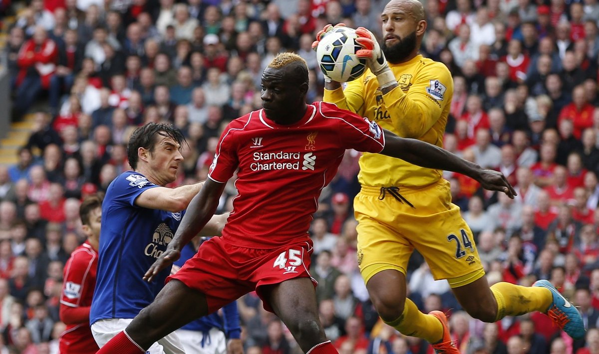 Liverpool's Balotelli and Everton's Baines jump as Everton's goalkeeper Howard catches the ball during their English Premier League soccer match at Anfield in Liverpool