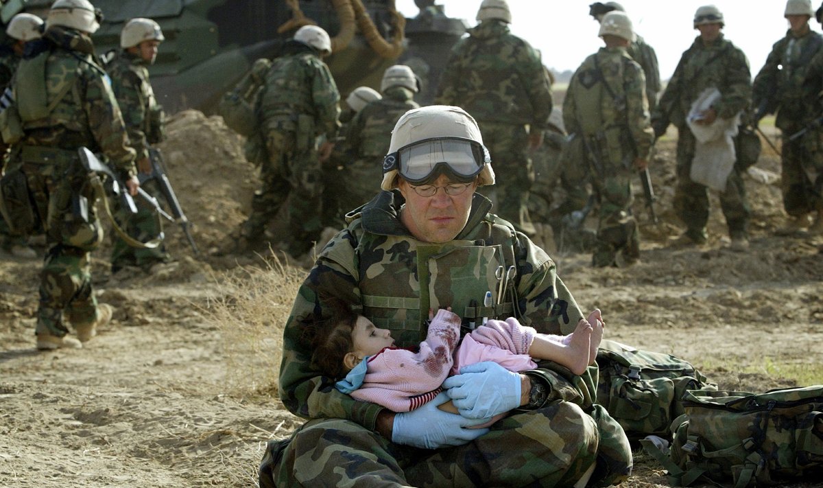 Iraagi sõda 2003. USA sõdur hoiab süles Iraagi last, kelle pere sai kahe tule vahel surma.