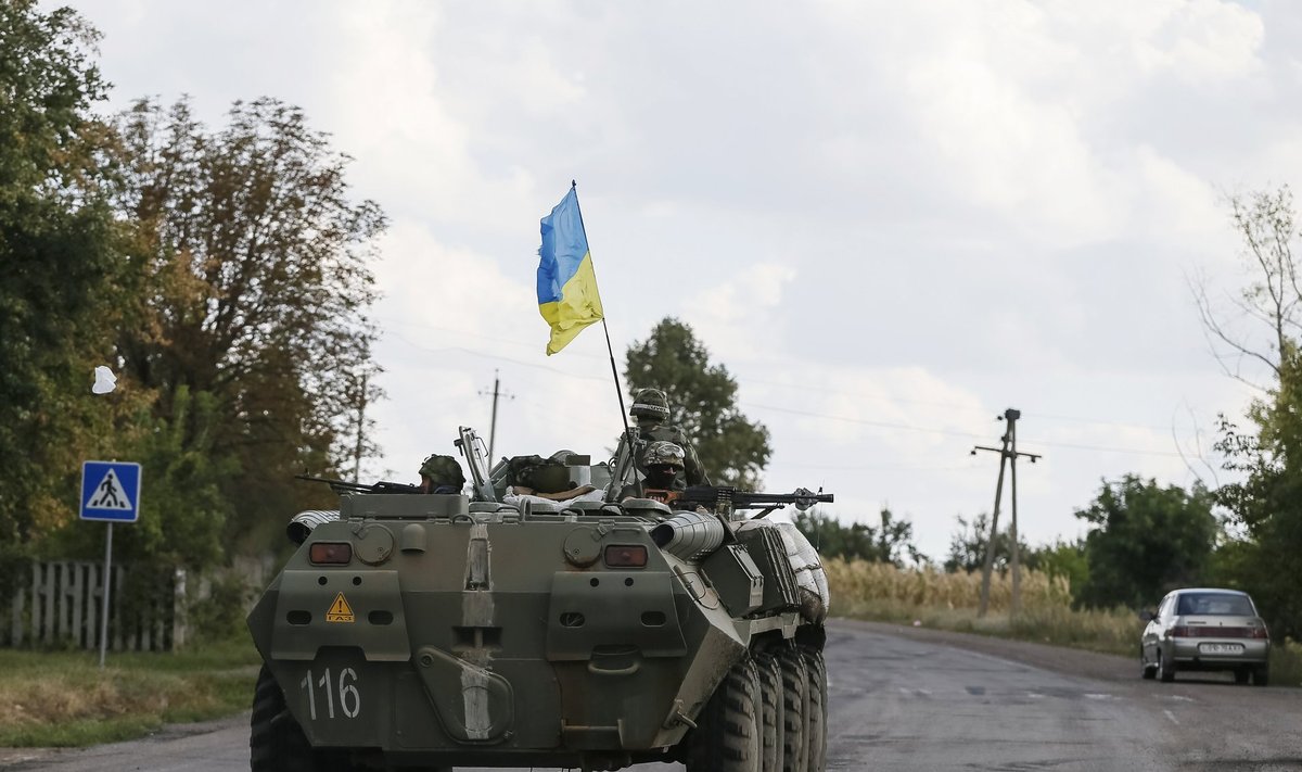 Ukrainian servicemen ride in an armoured vehicle near Debaltseve
