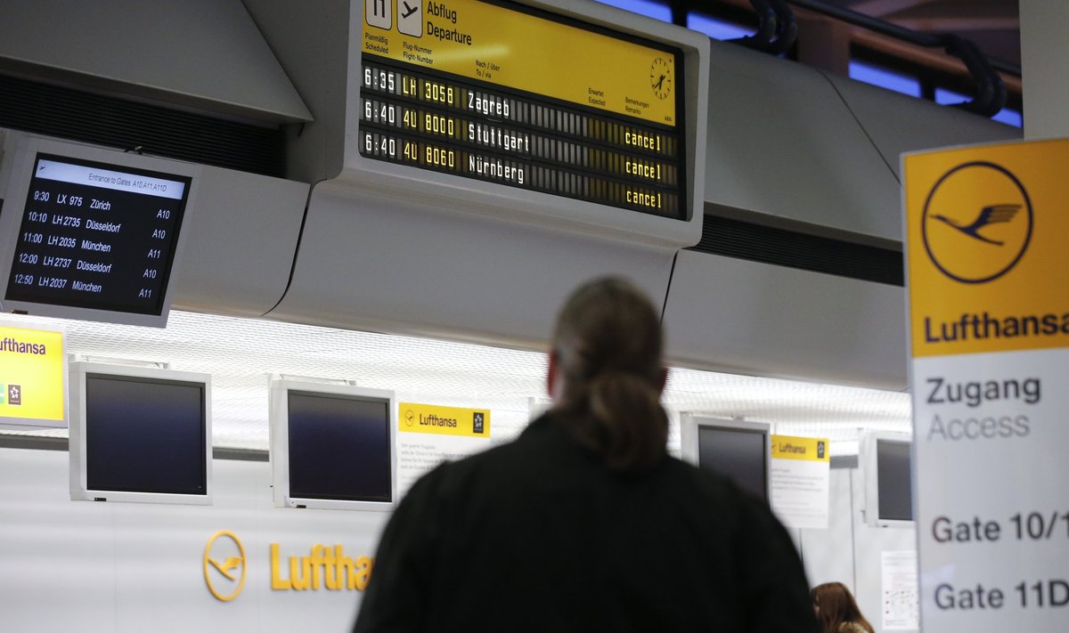 A man looks at cancelled flights by German air carrier Lufthansa on a flight schedule board at Berlin Tegel airport