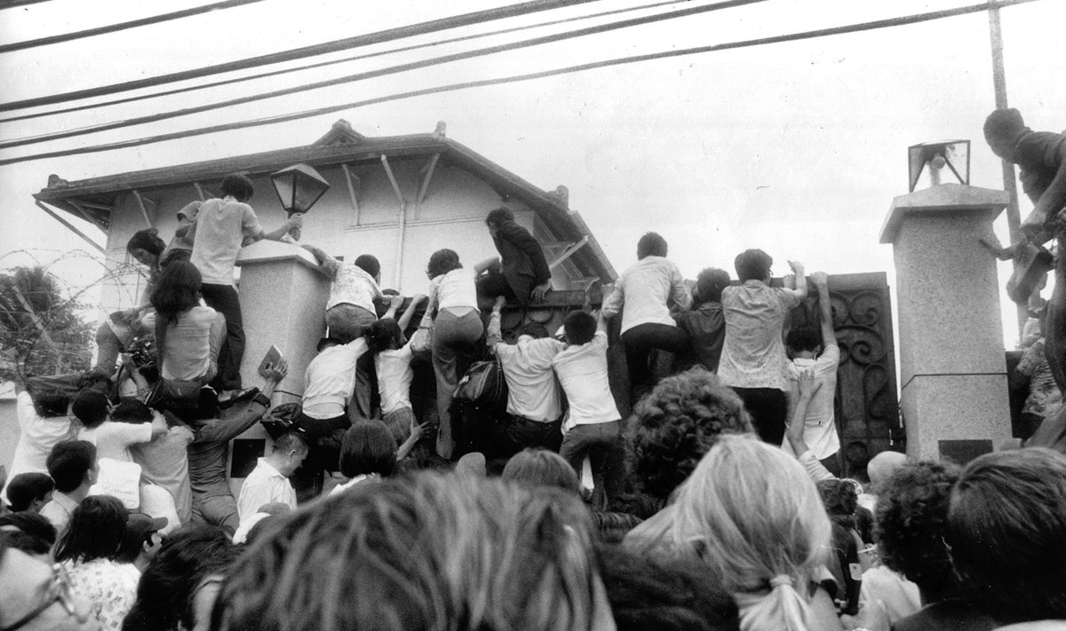 Южные вьетнамцы пытаются спастись бегством, пробираясь на территорию посольства США в Сайгоне. 30 апреля 1975.