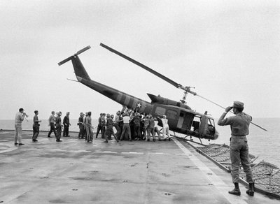 Экипаж сталкивает вертолет UH-1 Huey с борта авианосца USS Blue Ridge, чтобы освободить палубу для эвакуируемых