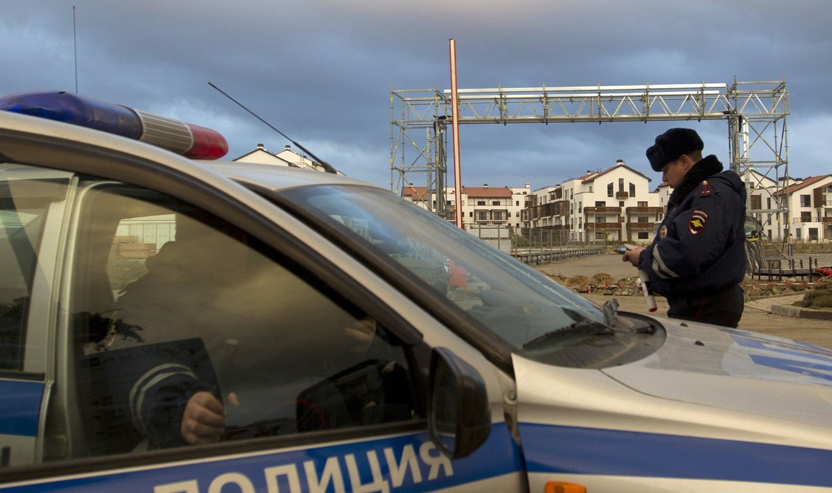 Russian police patrol in a car near accomodation and venues in the Olympic Park in Adler near Sochi