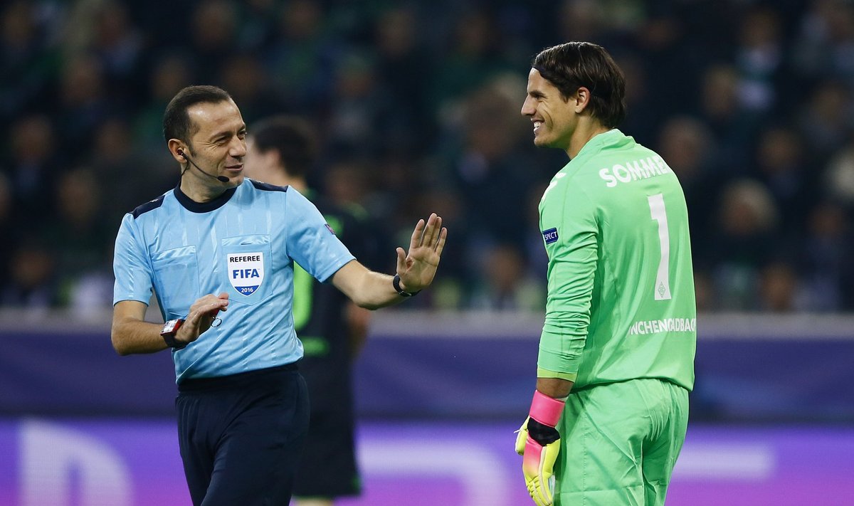 Referee Cuneyt Cakir speaks to Borussia Monchengladbach's Yann Sommer