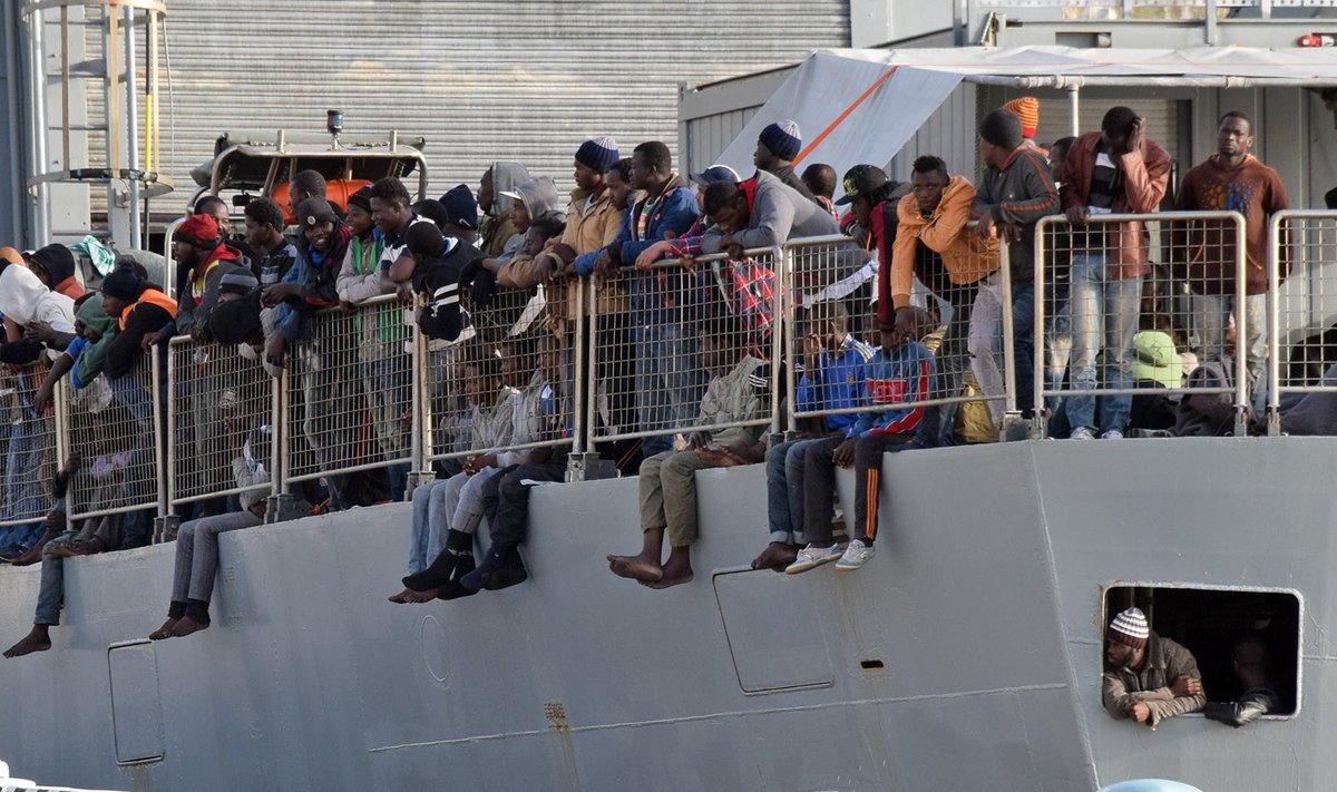 Liibüast saabunud põgenikud ootavad Itaalia rannikul sõjalaevalt maale pääsemist