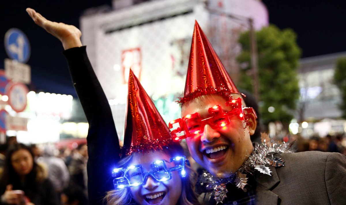 Revellers wearing glasses in the shape of 2017 pose during a new year countdown event at Shibuya crossing in Tokyo, Japan