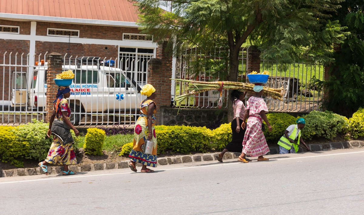 Tänavapilt Rwandas. Naised kannavad pea peal kompse, samaaegselt toimub tänavakoristus mis oli Rwandas tavapärane vaatepilt. Rwanda on Aafrika kõige puhtam riik.