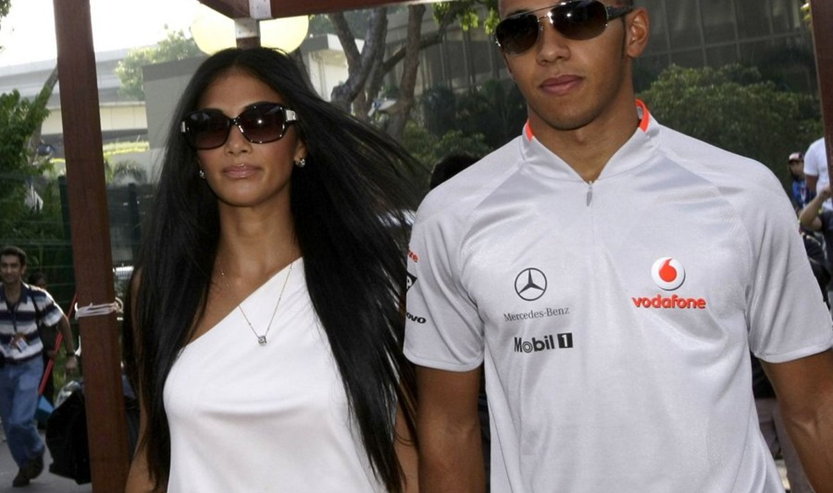 Formula One McLaren driver Lewis Hamilton of Britain walks with singer Nicole Scherzinger before the qualifying session of the Singapore F1 Grand Prix at the Marina Bay street circuit September 26, 2009. REUTERS/Tim Chong (SINGAPORE SPORT MOTOR RACING ENTERTAINMENT)