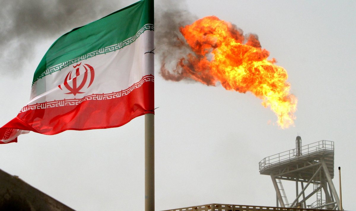 FILE PHOTO: A gas flare on an oil production platform in the Soroush oil fields is seen alongside an Iranian flag in the Persian Gulf