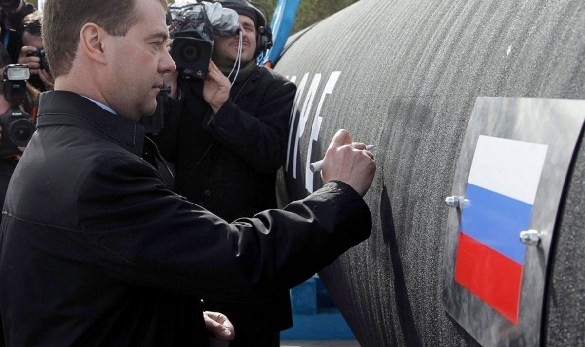 Russian President Dmitry Medvedev writes 'Good Luck!' on a pipe of the Nord Stream pipeline near Russian town of Vyborg on April 9, 2010. AFP PHOTO / RIA NOVOSTI / KREMLIN POOL / VLADIMIR RODIONOV