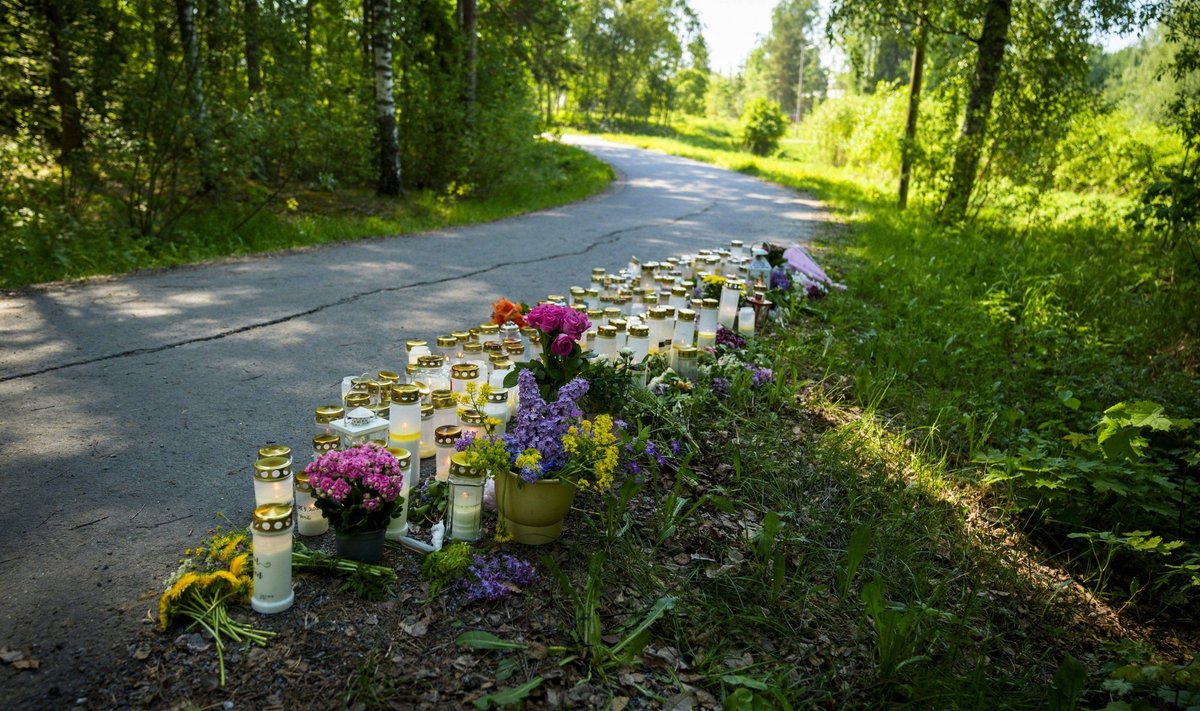 К обочине дороги люди принесли цветы и свечи. Девочку-подростка изнасиловали и убили в этом лесу.
