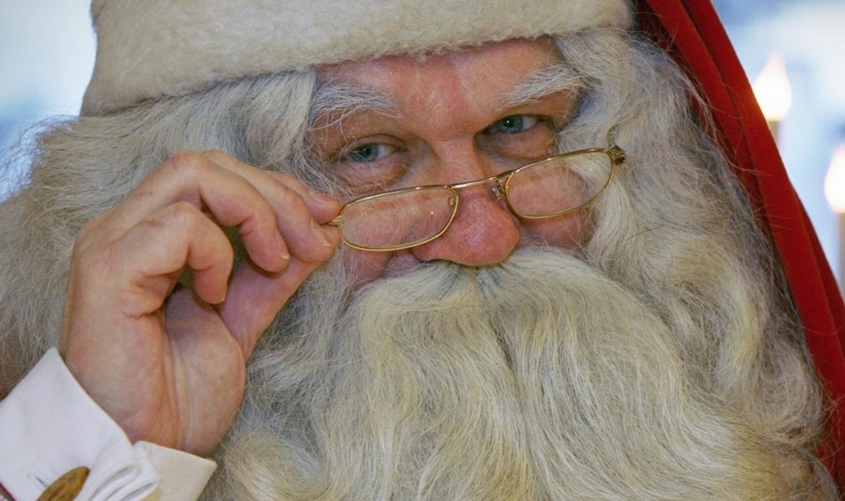 A man dressed as Santa Claus takes a break from reading childrens' letters at the Santa Claus Office located on the Arctic Circle near Rovaniemi November 26, 2009. REUTERS/Bob Strong  (FINLAND SOCIETY)