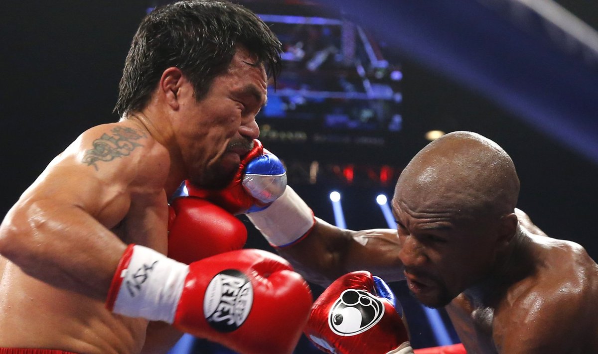 Pacquiao of the Philippines takes a punch from Mayweather, Jr. of the U.S. in the fourth round during their welterweight title fight in Las Vegas