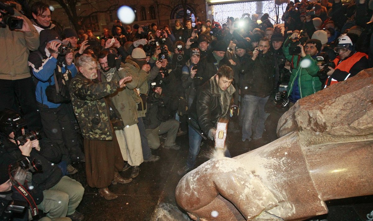 People surround a statue of Soviet state founder Vladimir Lenin, which was toppled by protesters, during a rally organized by supporters of EU integration in Kiev
