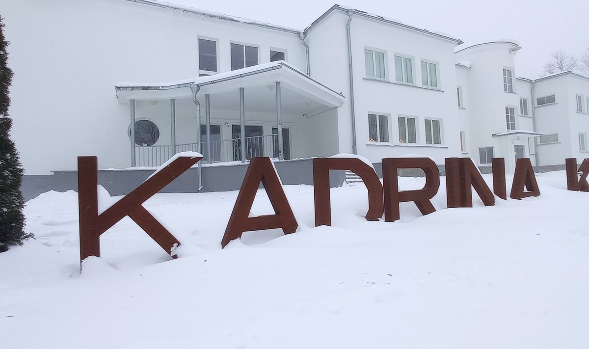 Kadrina keskkool oli e-õppel juba esmaspäeval ja see jätkub ka teisipäeval, et säästa õppurite-õpetajate tervist. Pildil on lumme uppunud koolisilt inimtühja koolimaja ees inimtühjal külatänaval.