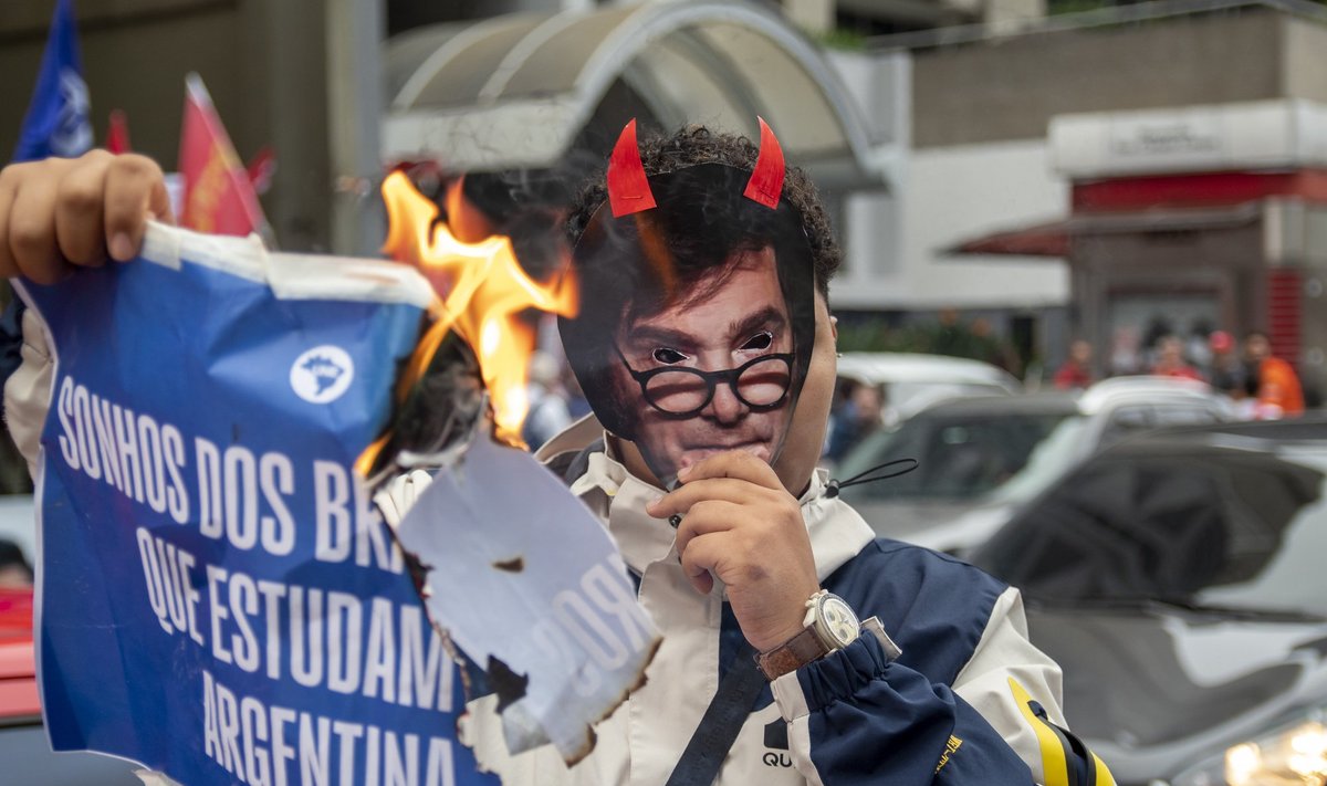 Protestija põletab São Paulo linnas meeleavaldusel plakatit, millel on kirjas „Riik ei ole müügiks“.