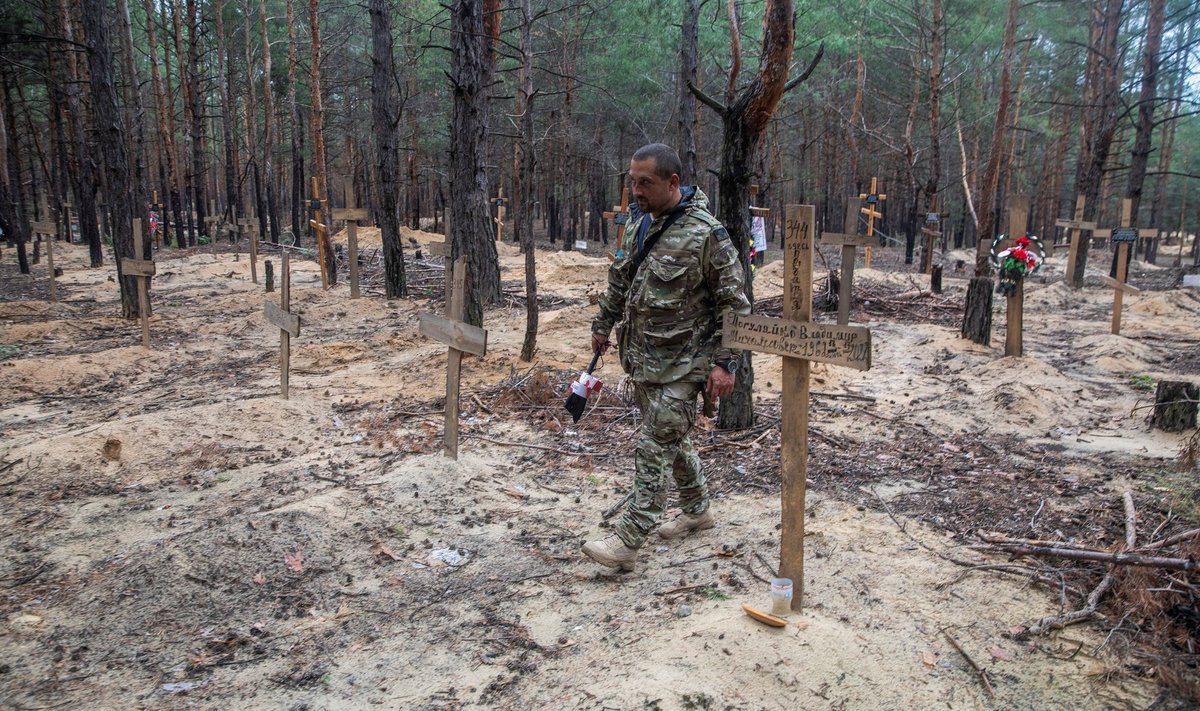 Украинский солдат на захоронении, обнаруженном под Изюмом
