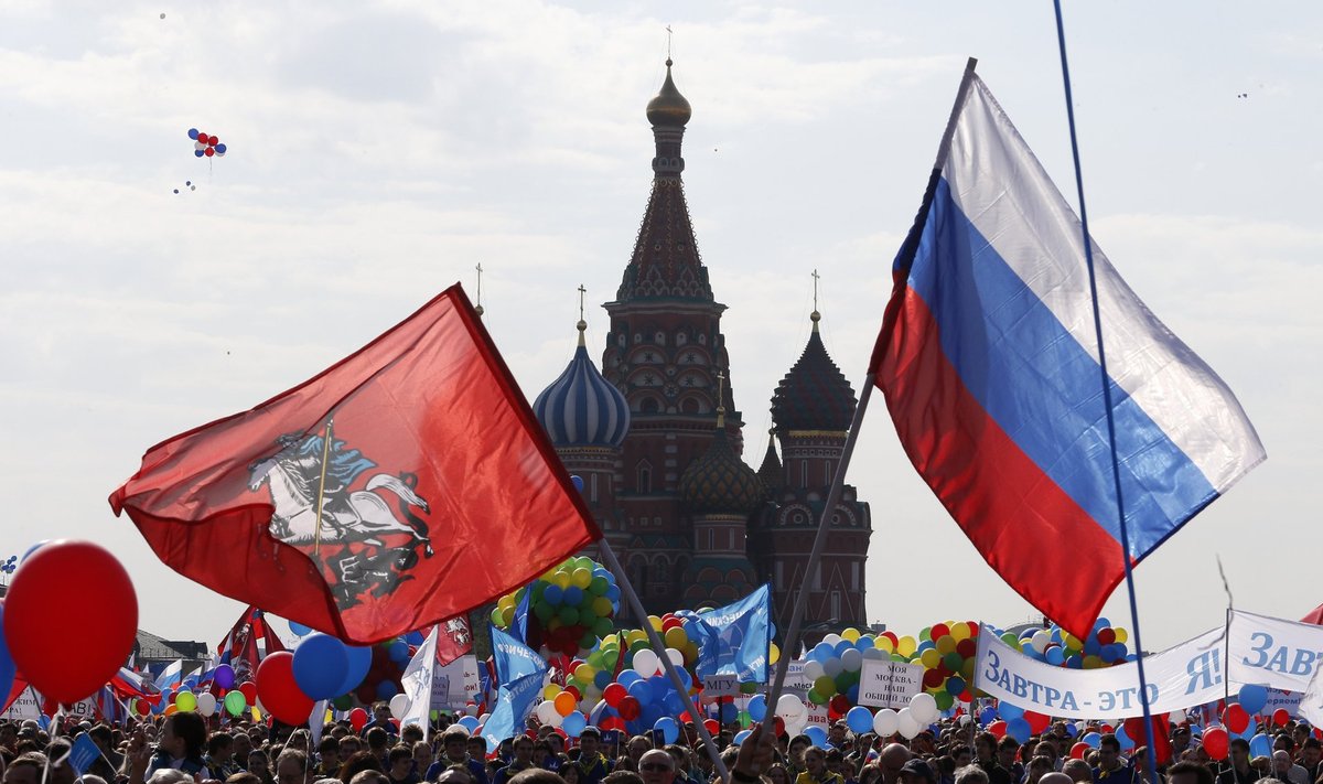 People walk through Red Square with flags and banners during a rally in Moscow