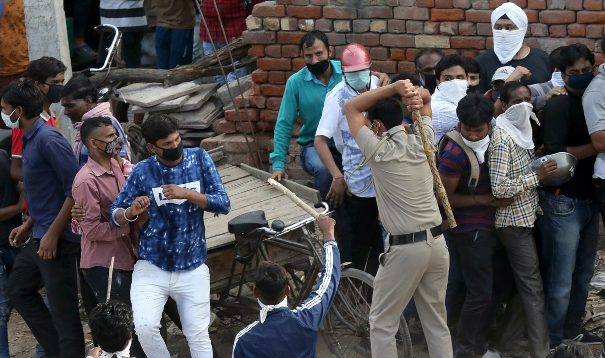 India politsei ajamas alkoholipoodide ette kogunenud rahvahulki laiali
