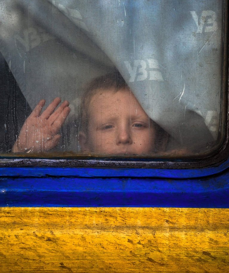 Laps Pokrovskis evakuatsioonirongi aknast välja vaatamas. Foto tehtud 30. novembril 2022.