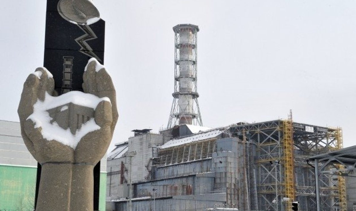 Tšernobõli tuumajaam katastroofis hukkunute memoriaali taustal. Foto Sergei Supinski, AFP