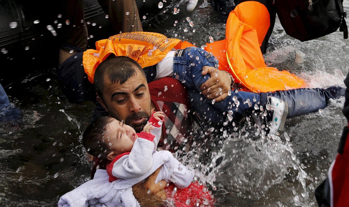 Süüria põgenik hoiab lapsi vee peal. Jäänud on viimased meetrid, jõudmaks Kreekasse Lesbose saarele.
