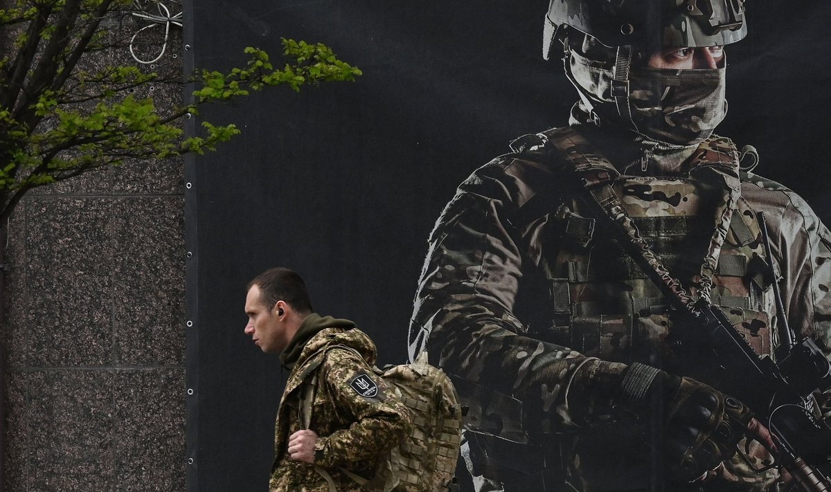 OTSITAKSE VÕITLEJAID: Ukraina sõdur kõnnib Kiievis mööda hiiglaslikust värbamisplakatist. 