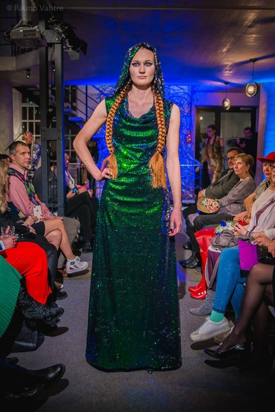 Perit Muuga litritega kleit üllatab kapuutsi ja imekauni rohelise tooniga, mille kõrval soeng ja aksessuaarid võiksid jääda minimalistlikuks.