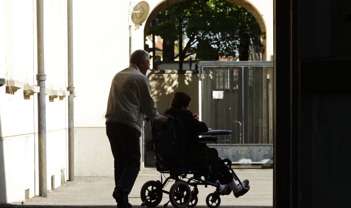 Liikumispuudega inimene ja tema hooldaja Itaalias. Foto on illustreeriva tähendusega