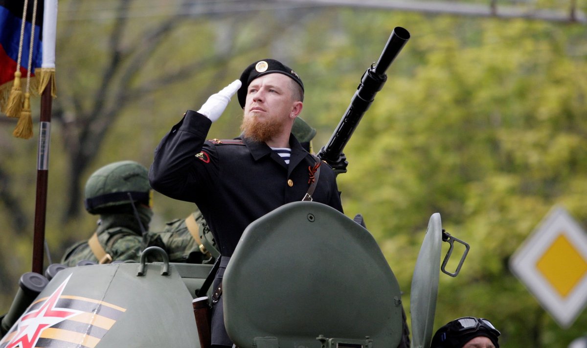 Former pro-Russian separatist Pavlov sits atop of an armoured personnel carrier during the Victory Day parade to mark the end of World War Two, in Donetsk