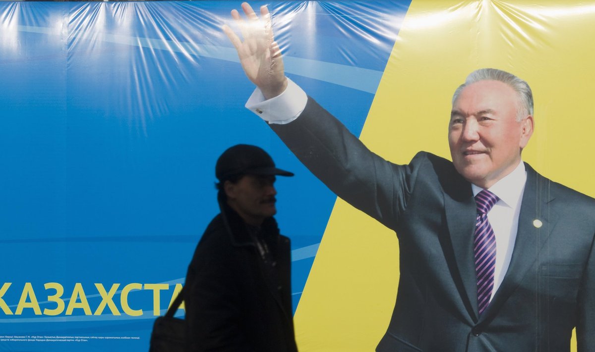 A man passes by an election poster of the Hur Otan party, displaying a portrait of Kazakhstan's President Nazarbayev, in Almaty