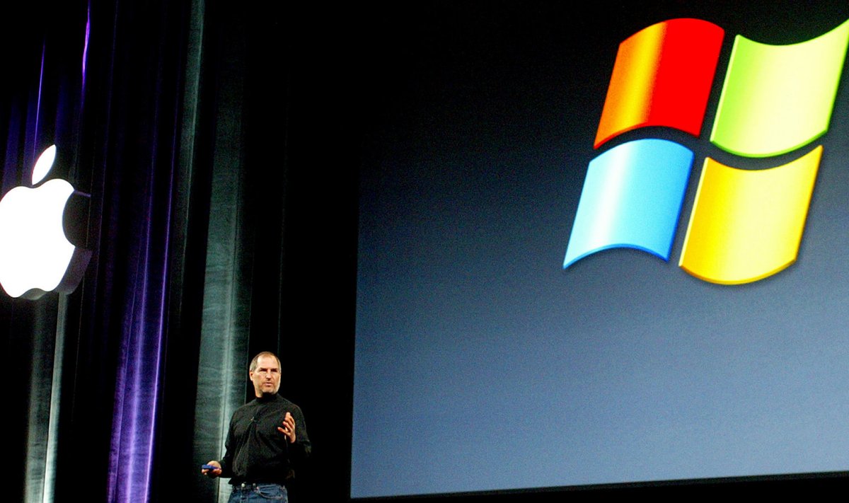 Steve Jobs Apple'i ja Microsofti logode vahel