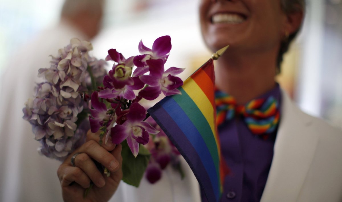Faith Kassan, 46, holds a rainbow flag with her bouquet before getting married to her fiancee Jennifer Ehrman in West Hollywood