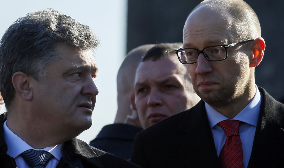 Ukraine's President Poroshenko talks to Prime Minister Yatseniuk after a wreath laying ceremony at the Unknown Soldier's Tomb in Kiev