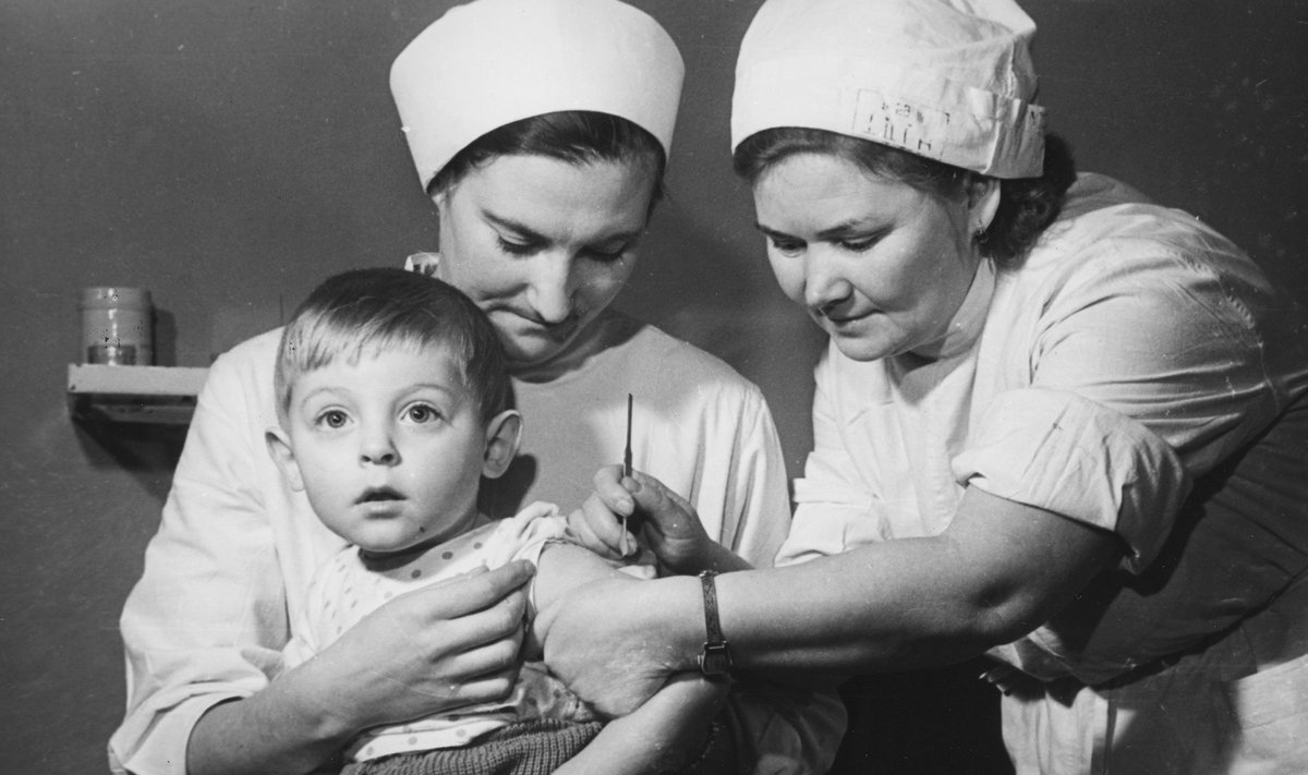 PILT MINEVIKUST: Tallinna Keskrajooni lastehaigla vaktsineerimiskabineti töötajad J. Jõgi (istub) ja Z. Podlobko rõugete vastu kaitsepookimist teostamas. 1979. aastal kuulutas WHO, et rõuged on likvideeritud.